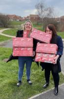 Helen presents Easter eggs to Laura Fenwick from the Young Carers Charity